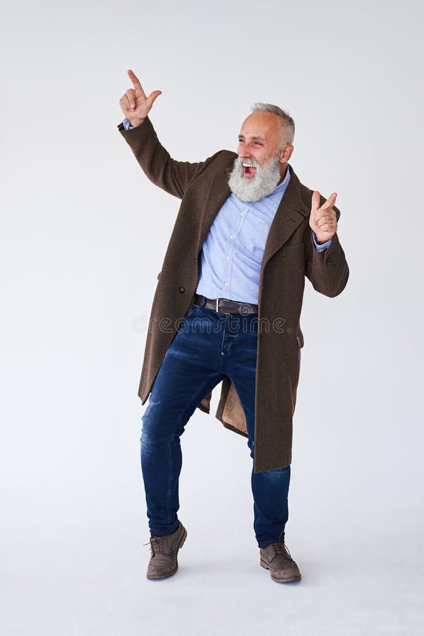 Barbu mûr beau dans le manteau soulevant des mains dans le studio images stock Barbu mûr beau dans le manteau soulevant des mains dans le studio images stock