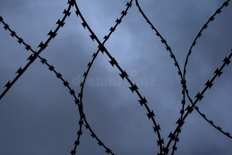 Close up shot of a barbwire at the top of a wall