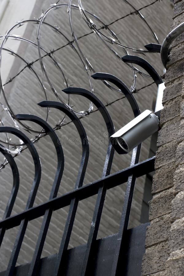 Barbwire and observation camera on the wall. Barbwire and observation camera on the wall