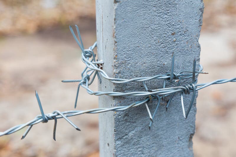 Barbwire wrapped around concrete post royalty free stock images