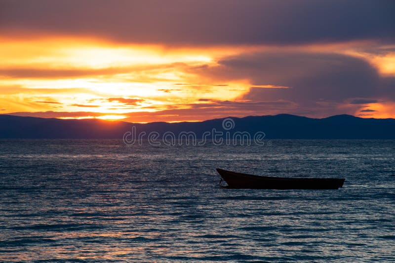Barca di legno sul lago Baikal al tramonto immagini stock libere da diritti Barca di legno sul lago Baikal al tramonto immagini stock libere da diritti