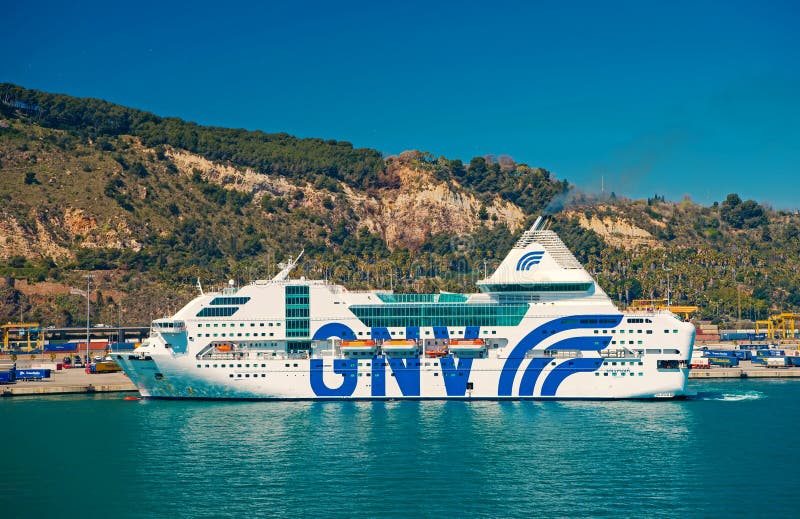 Barcelona, Espa?a - 30 de marzo de 2016: rapsodia G?nova del barco de cruceros GNV en el mar en paisaje de la monta?a Destino de fotografía de archivo libre de regalías Barcelona, Espa?a - 30 de marzo de 2016: rapsodia G?nova del barco de cruceros GNV en el mar en paisaje de la monta?a Destino de fotografía de archivo libre de regalías