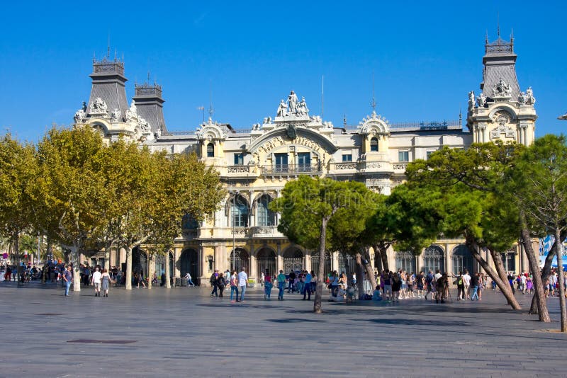 BARCELONA, SPAIN - OCTOBER 18, 2014: Tourists near old Barcelona Port Authority building, Port de Barcelona, at the base of stock image BARCELONA, SPAIN - OCTOBER 18, 2014: Tourists near old Barcelona Port Authority building, Port de Barcelona, at the base of stock image