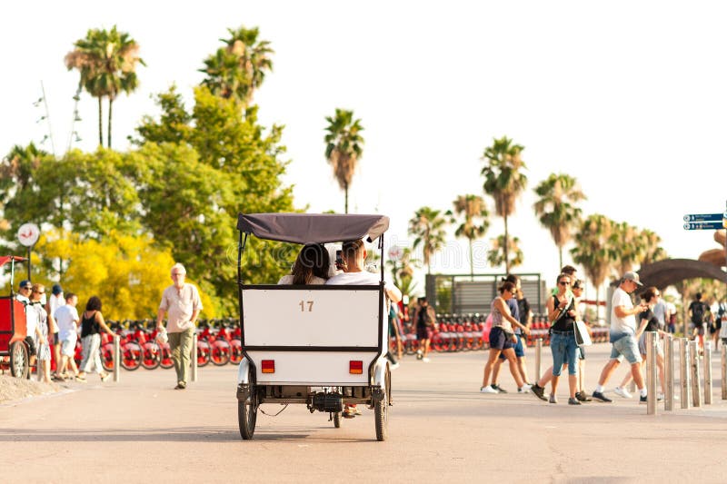 Barcelone, Espagne - 7 juillet 2019 : touristes dans le pousse-pousse de cycle au coucher du soleil dans le vieux port de ville a photo stock Barcelone, Espagne - 7 juillet 2019 : touristes dans le pousse-pousse de cycle au coucher du soleil dans le vieux port de ville a photo stock
