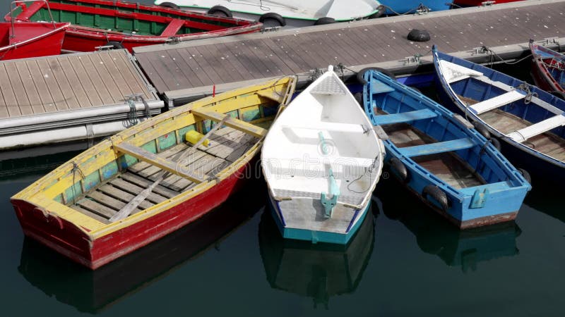 Barche colorate in legno per la navigazione in mare spagnolo con acqua strappata in tranquillità stock footage