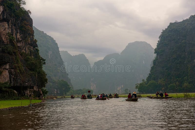 Barche di fila su un fiume sotto il cielo fuso nel Vietnam immagini stock libere da diritti Barche di fila su un fiume sotto il cielo fuso nel Vietnam immagini stock libere da diritti