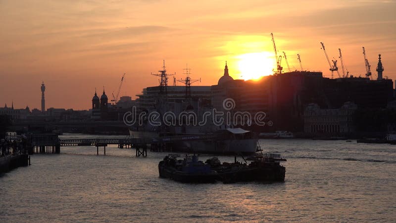 Barche a londra battono sul fiume Tamigi nella città di crepuscolo, al tramonto, in centro città si vedono edifici famosi segni di