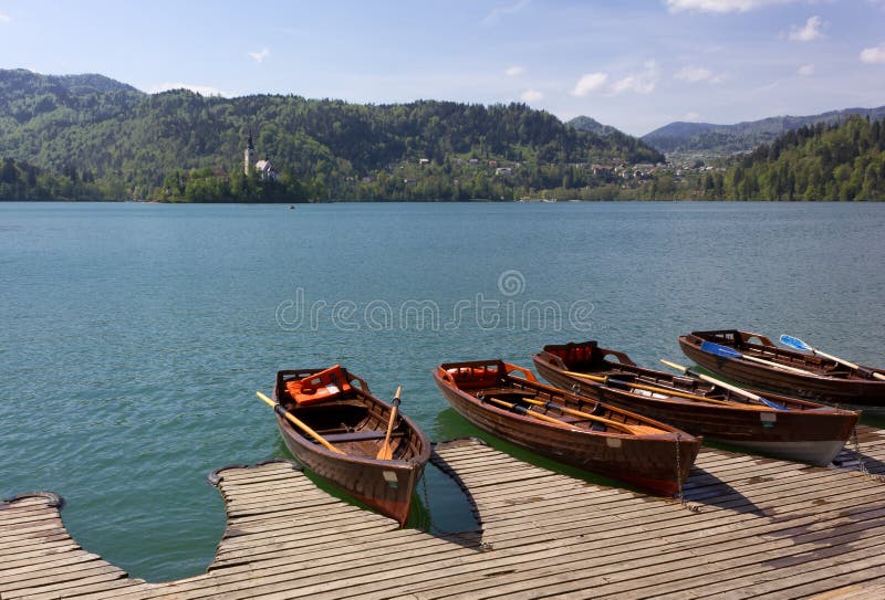 Barche a remi di legno nel lago sanguinato immagine stock libera da diritti Barche a remi di legno nel lago sanguinato immagine stock libera da diritti
