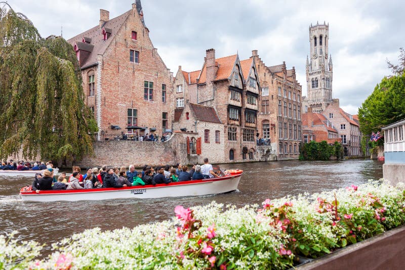 Barco completamente dos turistas no canal da água de Bruges em Bélgica foto de stock Barco completamente dos turistas no canal da água de Bruges em Bélgica foto de stock
