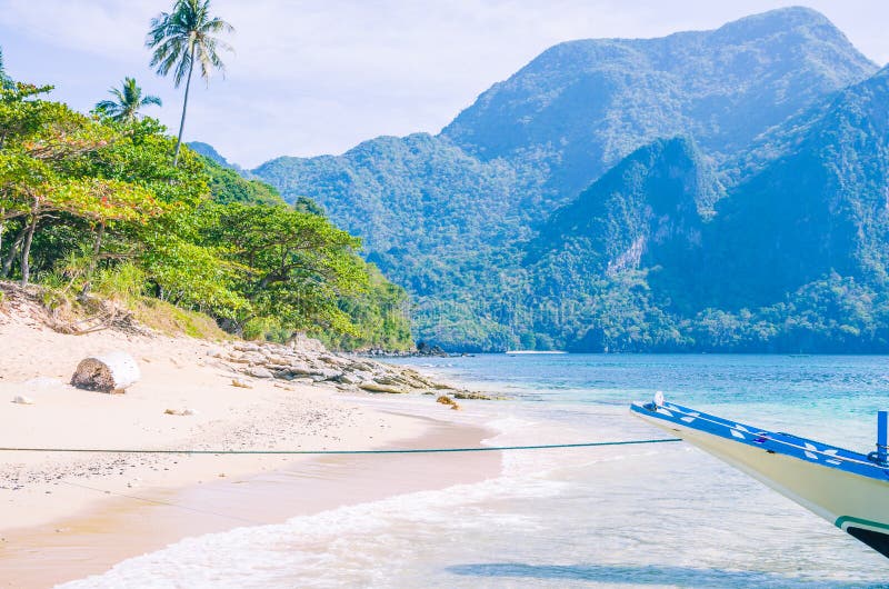 Barco de Banca na âncora na água clara no Sandy Beach perto do EL Nido, Filipinas fotografia de stock royalty free Barco de Banca na âncora na água clara no Sandy Beach perto do EL Nido, Filipinas fotografia de stock royalty free