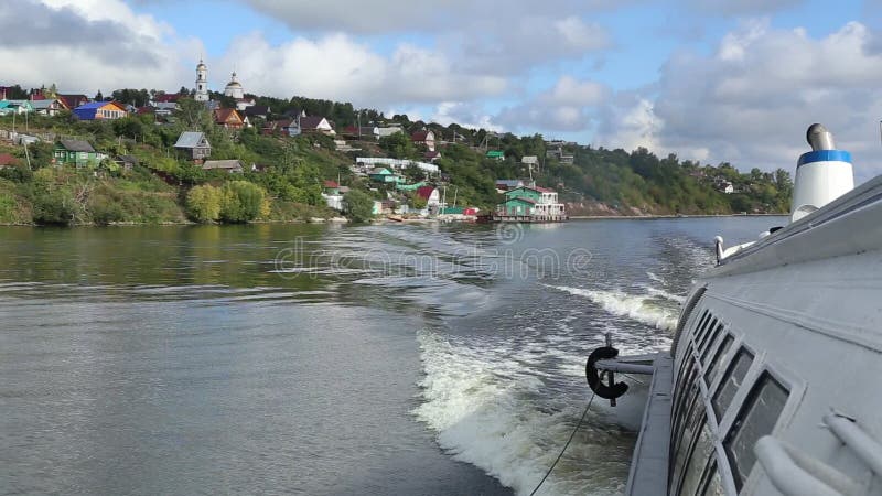 Barco de motor e uma vila pequena no Rio Volga