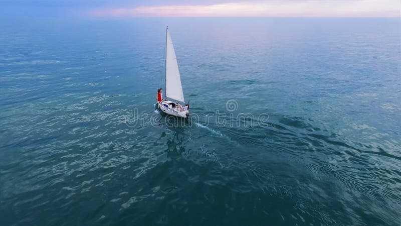 Barco de navigação branco com pares no mar, lazer de cruzamento romântico, liberdade imagem de stock Barco de navigação branco com pares no mar, lazer de cruzamento romântico, liberdade imagem de stock
