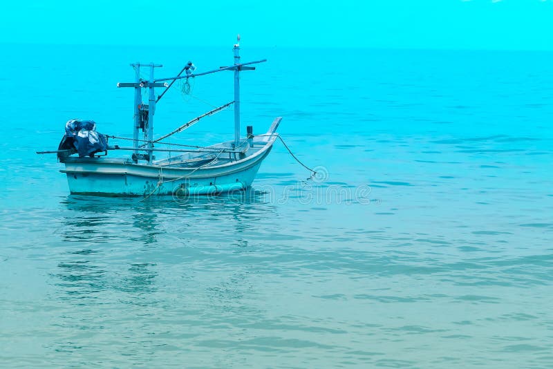 Barco de pesca cerca de la orilla en el mar azul y el cielo azul imagenes de archivo Barco de pesca cerca de la orilla en el mar azul y el cielo azul imagenes de archivo