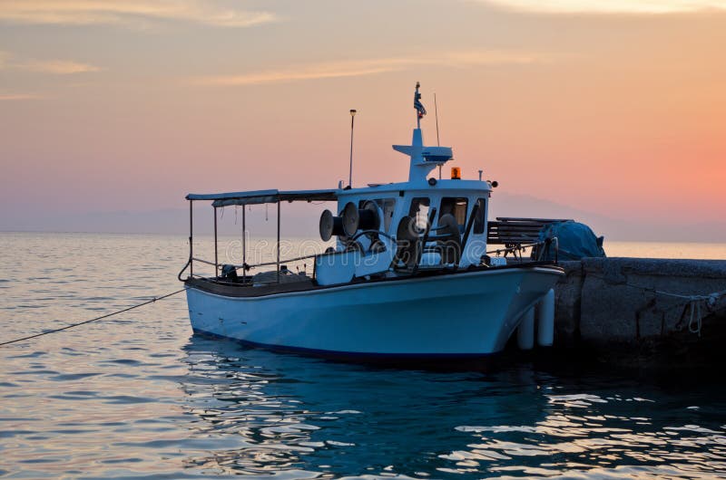 Barco de pesca na doca no por do sol imagem de stock Barco de pesca na doca no por do sol imagem de stock