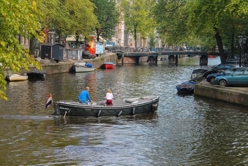 Barco de turista no canal de Amsterdão, os Países Baixos foto de stock Barco de turista no canal de Amsterdão, os Países Baixos foto de stock