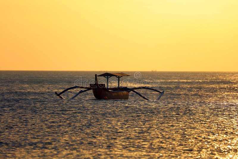 Barco del pescador sin el pescador en Bali, Indonesia durante puesta del sol en la playa fotografía de archivo Barco del pescador sin el pescador en Bali, Indonesia durante puesta del sol en la playa fotografía de archivo