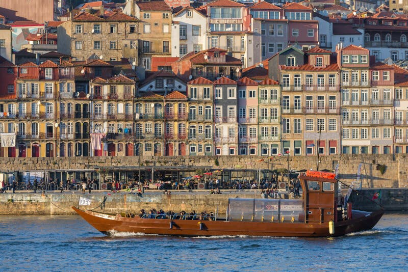 Barco do cruzeiro que passa por casas coloridas bonitas no beira-rio do rio de Douro na cidade velha de Porto foto de stock royalty free Barco do cruzeiro que passa por casas coloridas bonitas no beira-rio do rio de Douro na cidade velha de Porto foto de stock royalty free