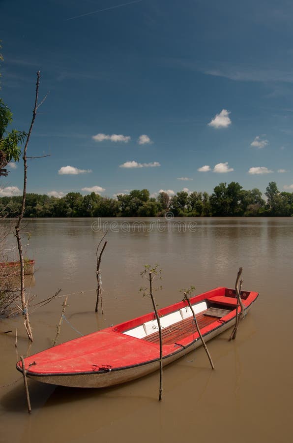 Barco plástico vermelho que flutua no rio fotografia de stock