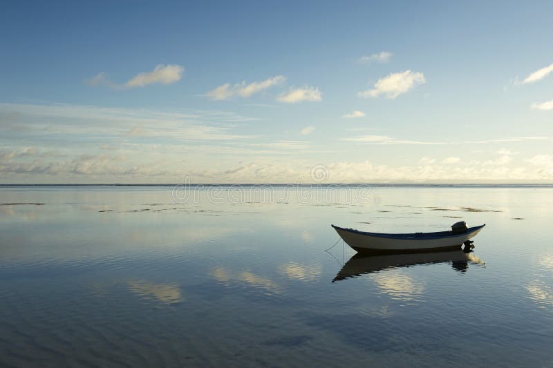 Barco simples a flutuar em águas calmas fotografia de stock
