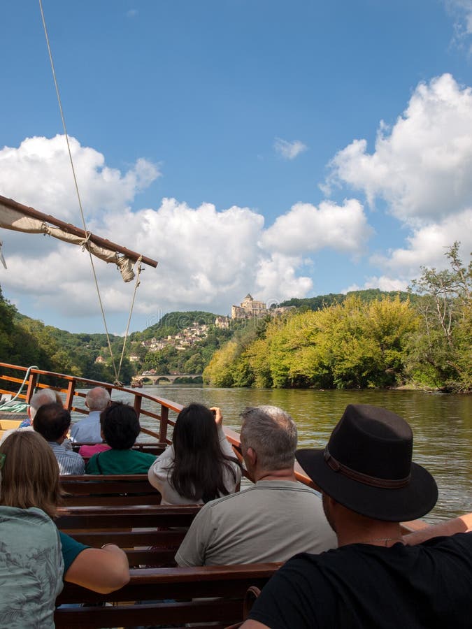 Castelnaud, Dordogne, France - September 7, 2018: A tourist boat, in French called gabare, on the river Dordogne at Castelnaud la Chapelle, Aquitaine, France. Castelnaud, Dordogne, France - September 7, 2018: A tourist boat, in French called gabare, on the river Dordogne at Castelnaud la Chapelle, Aquitaine, France