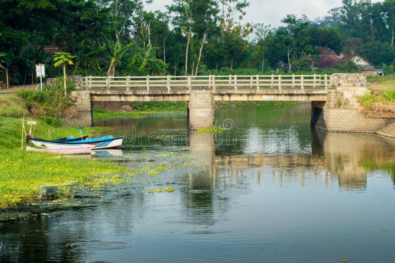 Barco y puente en un río tranquilo imagen de archivo Barco y puente en un río tranquilo imagen de archivo