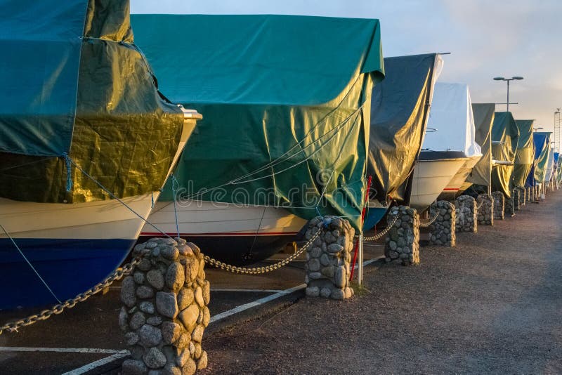 Boats covered with tarpaulin in winter storage in Kristiansand, Norway. Boats covered with tarpaulin in winter storage in Kristiansand, Norway