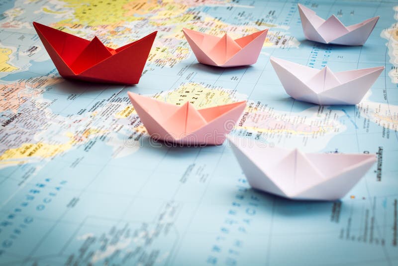 Barcos de papel que seguem um barco vermelho do líder fotografia de stock Barcos de papel que seguem um barco vermelho do líder fotografia de stock