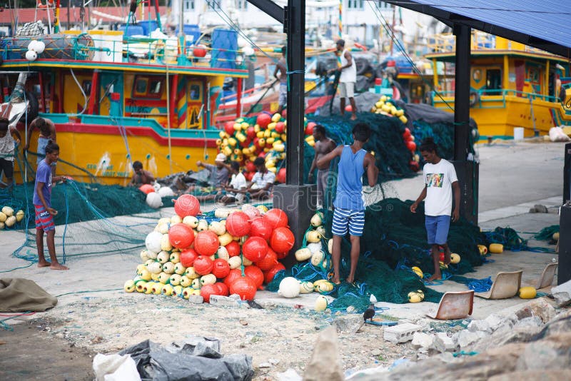Barcos de pesca tradicionais de Sri Lanka no porto de Mirissa Os pescadores desembaraçam redes de pesca foto de stock Barcos de pesca tradicionais de Sri Lanka no porto de Mirissa Os pescadores desembaraçam redes de pesca foto de stock