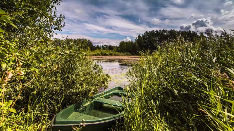 Barcos e nuvens de lago passam o tempo