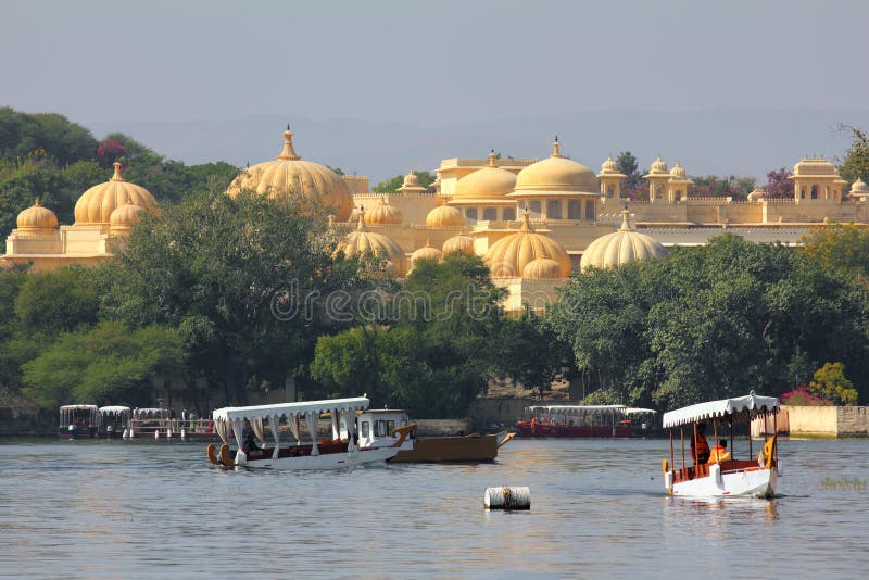 Barcos e palácio no lago Pichola imagem de stock royalty free Barcos e palácio no lago Pichola imagem de stock royalty free