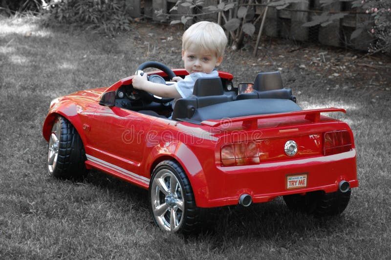 A young boy driving with his toy sports car. A young boy driving with his toy sports car