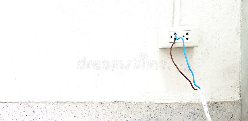 Bare blue and brown wire install and plug in to electrical outlet box on white cement wall stock image Bare blue and brown wire install and plug in to electrical outlet box on white cement wall stock image