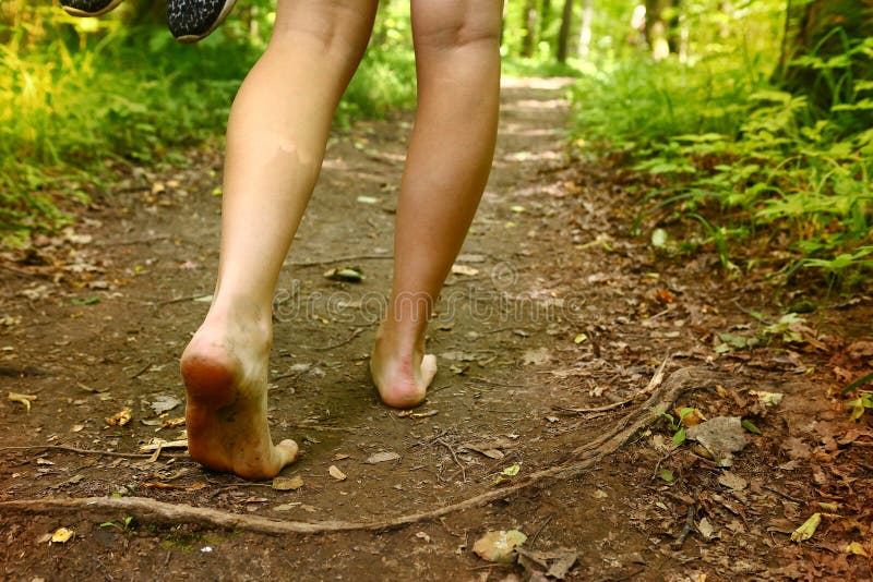 Bare feet walking along forest way close up photo