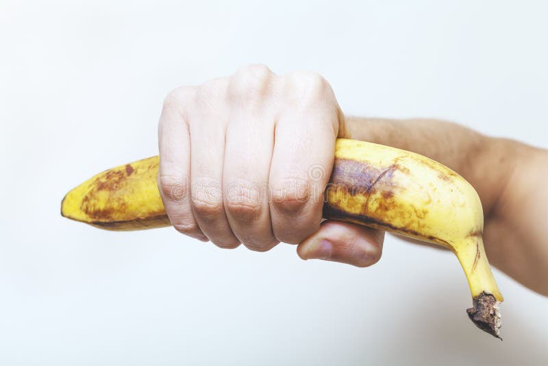 Bare hand holding banana. 