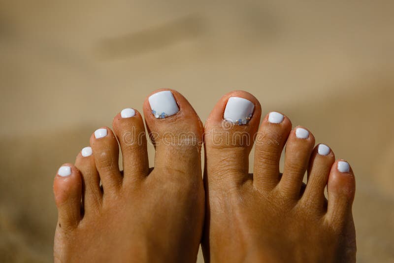 Woman`s legs on sand