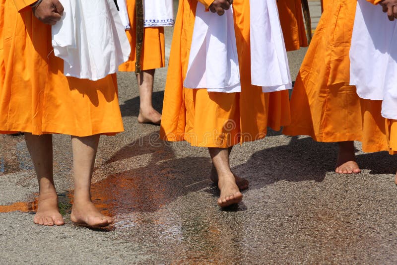 Barefooted people with orange dresses during the religious Sikh stock photo