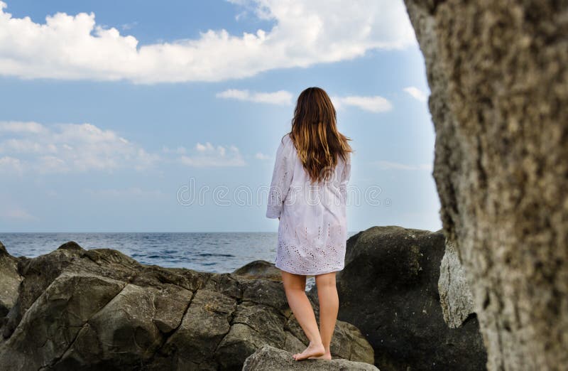 Barfüßigfrau, welche die Einsamkeit der Küste genießt