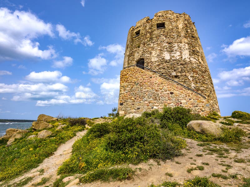 Close-up of `Torre di Barì`, a tower built on a rocky outcrop on the beach with beige sand and sea with crystalline water, Bari Sardo, Sardinia, Italy. Close-up of `Torre di Barì`, a tower built on a rocky outcrop on the beach with beige sand and sea with crystalline water, Bari Sardo, Sardinia, Italy