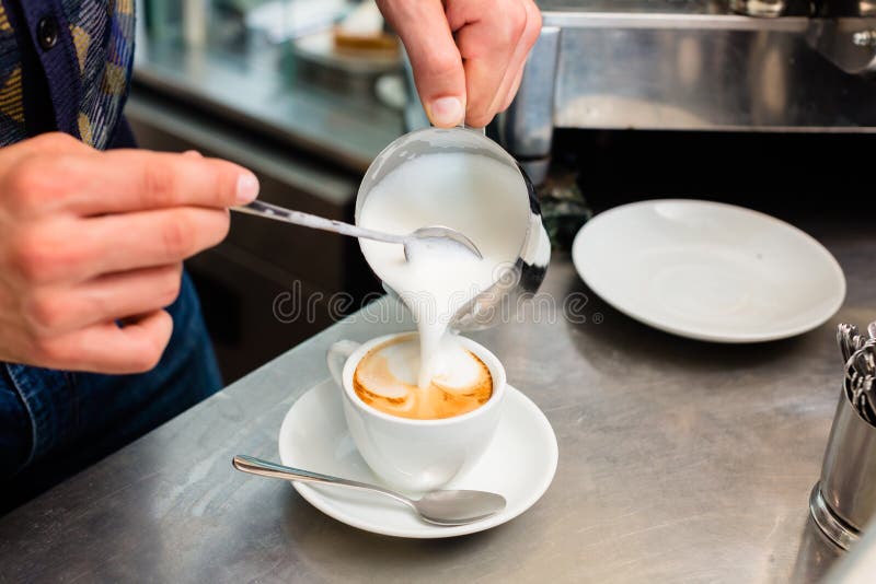 Barista in caffè o nel bar che prepara cappuccino