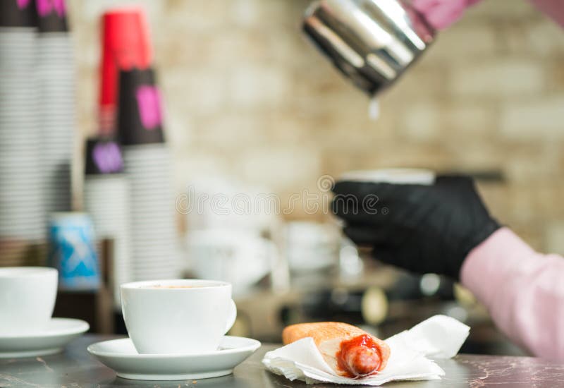 Barista che aggiunge latte nel caffè sullo sfondo fotografia stock Barista che aggiunge latte nel caffè sullo sfondo fotografia stock