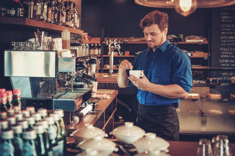 Barista che assaggia un nuovo tipo di caffè nella sua caffetteria immagine stock Barista che assaggia un nuovo tipo di caffè nella sua caffetteria immagine stock