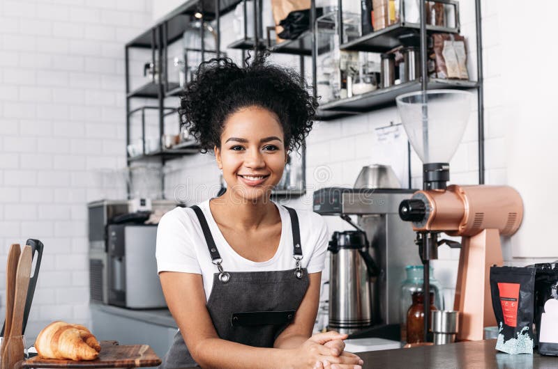 Barista de confianza con pelo rizado mirando la cámara imágenes de archivo libres de regalías