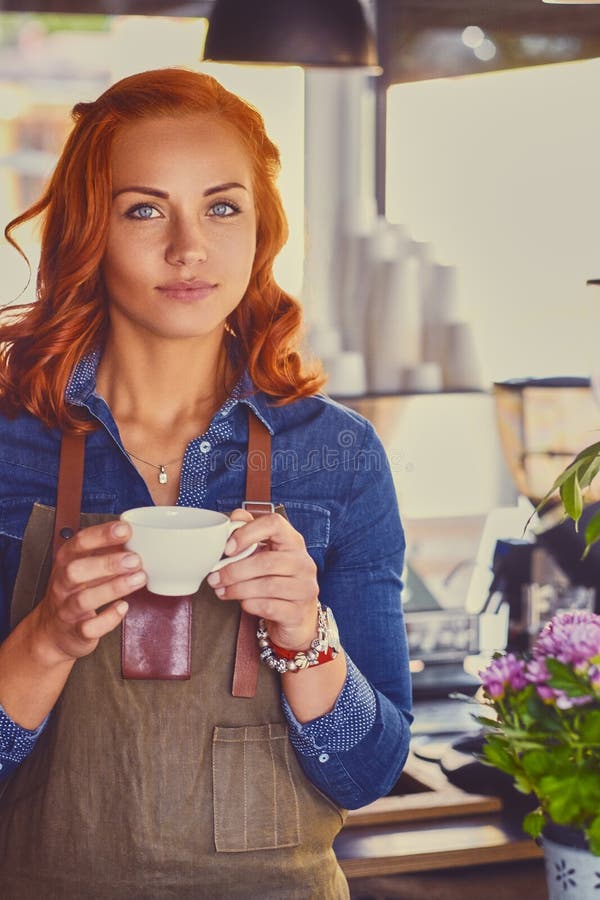 Barista femminile in una piccola caffetteria immagine stock