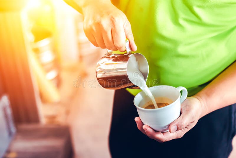 The Barista Make Ice Coffee and Milk in the Cup on the Table. Stock
