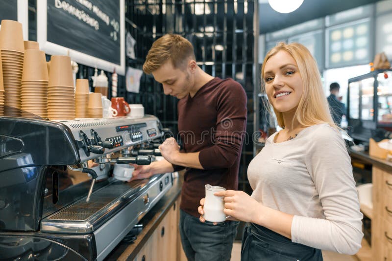 Barista man och kvinna som gör kaffe, par av ungdomarsom arbetar i coffee shop arkivfoto Barista man och kvinna som gör kaffe, par av ungdomarsom arbetar i coffee shop arkivfoto
