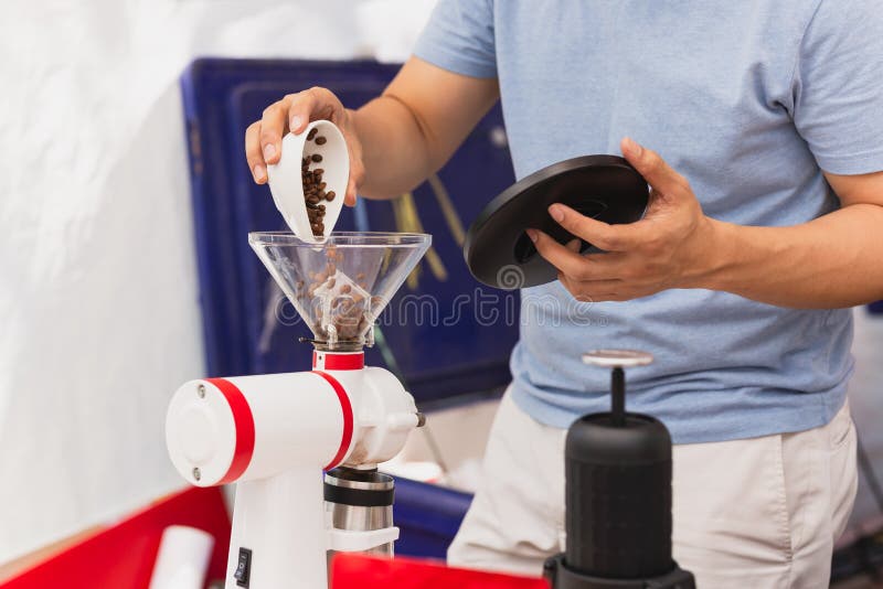 Barista Pouring Coffee Beans into the Coffee Machine Grinder To Make