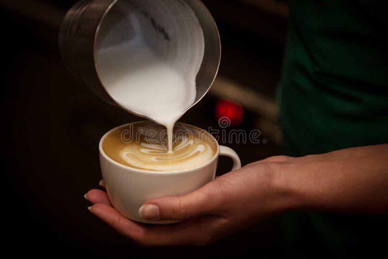 Barista pouring milk in a coffee cup stock image Barista pouring milk in a coffee cup stock image