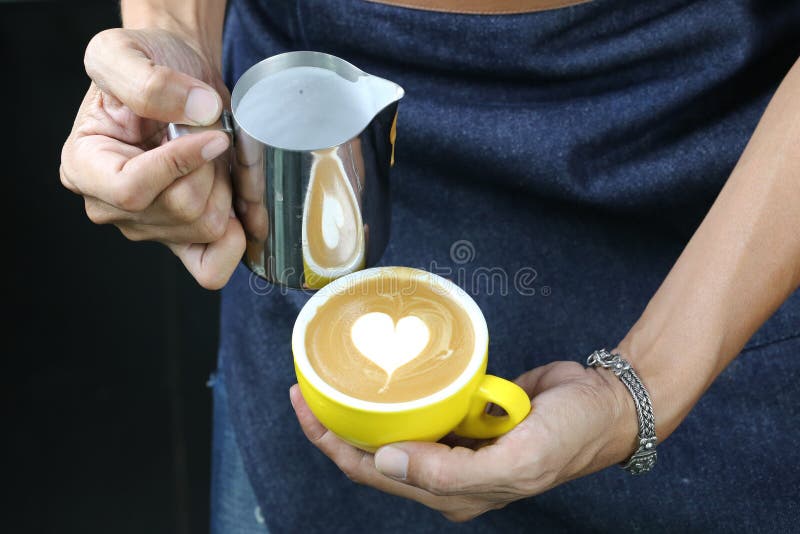 Barista pouring milk foam for making coffee latte art with pattern the heart in a cup royalty free stock images Barista pouring milk foam for making coffee latte art with pattern the heart in a cup royalty free stock images