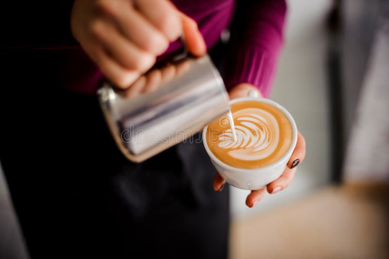 Barista que faz uma arte do leite no copo do café imagem de stock Barista que faz uma arte do leite no copo do café imagem de stock
