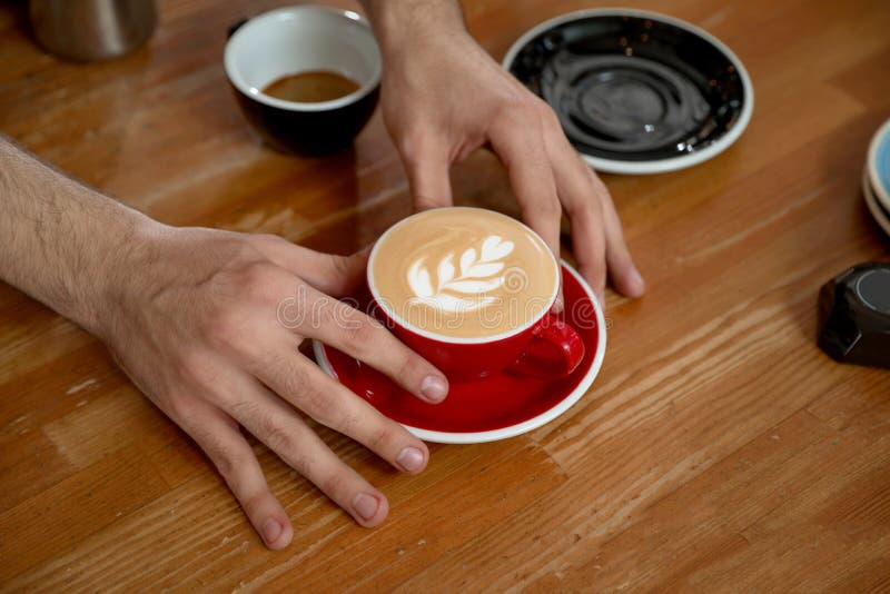 Barista que pone la taza de café en la tabla fotografía de archivo